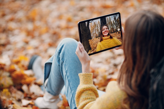 Modèle de jeune femme dans le parc d'automne avec des feuilles d'érable à feuillage jaune. Mode de la saison d'automne.