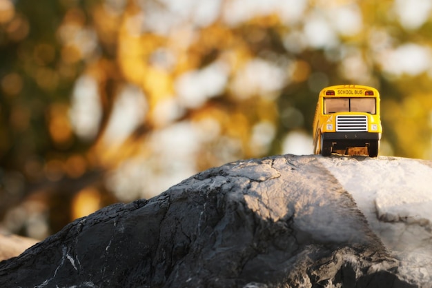 Modèle de jouet d'autobus scolaire jauneRetour à l'arrière-plan du concept d'éducation scolaire