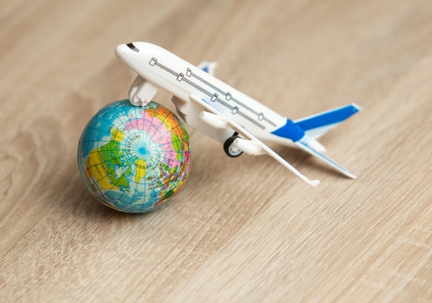 Photo modèle de jouet d'un avion de passagers avec un globe sur une table en bois