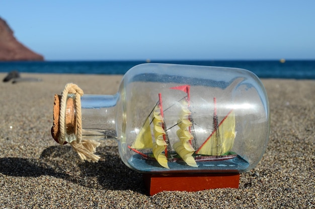 Modèle de jouet de bateau à voile dans le gros plan de sable de plage