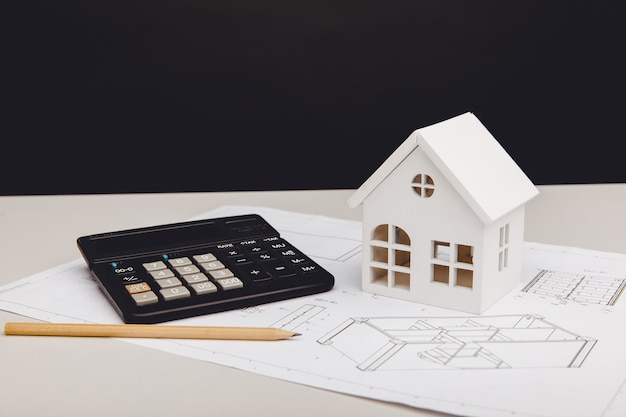 Modèle de maison et calculatrice sur le concept de coûts de construction de maison de projet architectural