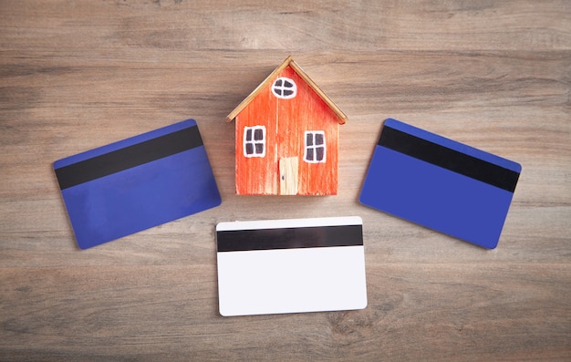 Modèle de maison et carte de crédit sur la table en bois.