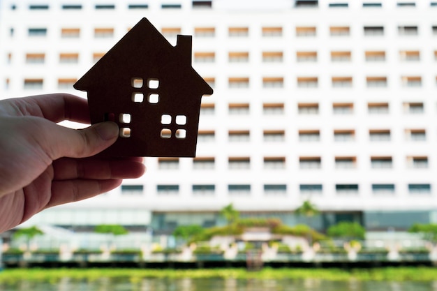 Photo modèle de maison dans la main de l'agent de courtier d'assurance habitation