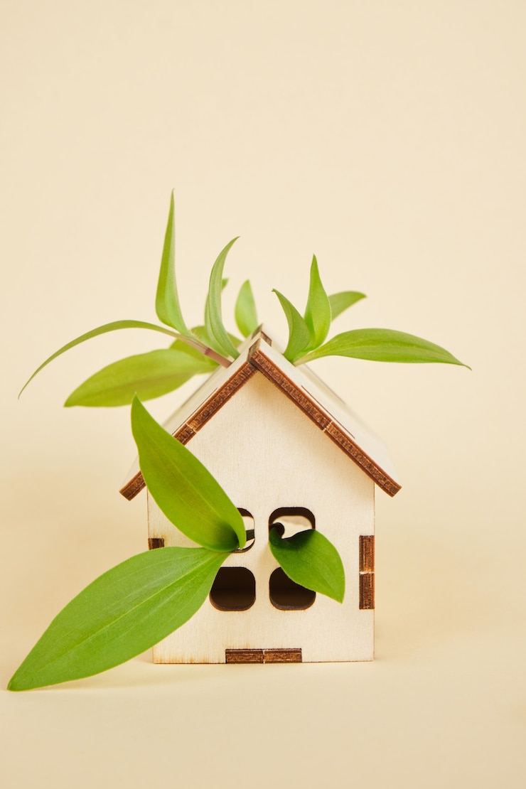 Photo modèle d'une maison sur fond beige, concept de maison écologique, feuilles et espace de copie de maison de jouet