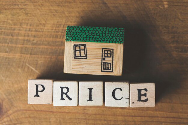 Photo modèle de maison avec mot de prix fabriqué à partir de blocs de bois concept de financement à domicile