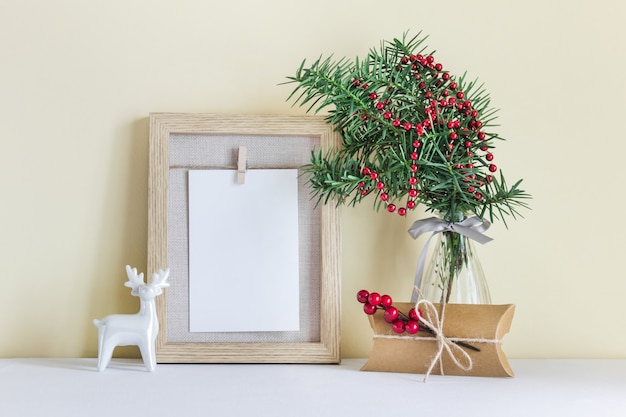 Modèle de maquette de cadre de Noël, nouvel an avec cadeau de décoration de Noël, renne blanc, branche de sapin à feuilles persistantes dans un vase en verre.