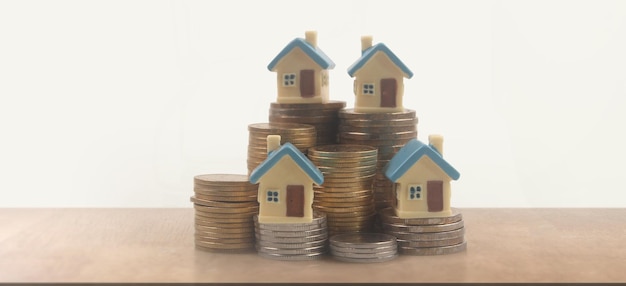 Modèle de maquette de maison miniature détachée et pièces de monnaie. concept d'investissement immobilier immobilier