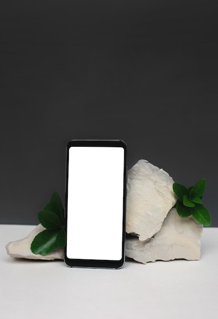 Modèle de maquette avec smartphone vertical sur pierres naturelles sur fond blanc-gris. Style minimaliste