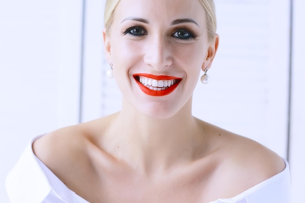 modèle avec maquillage professionnel et lèvres rouge vif / beau maquillage sur le visage du modèle, saturé de rouge à lèvres rouge vif sur les lèvres