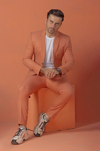 Modèle masculin posant en costume orange