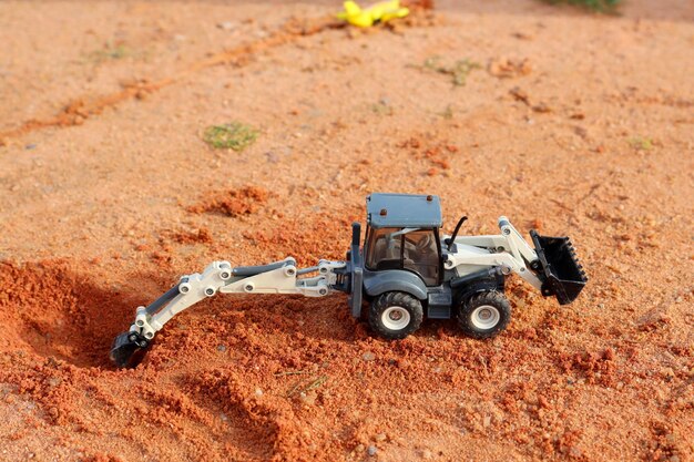 Modèle miniature d'une excavatrice creusant le sol sur un chantier de construction Jouets pour enfants