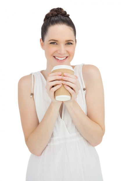 Modèle naturel souriant en robe blanche, boire du café