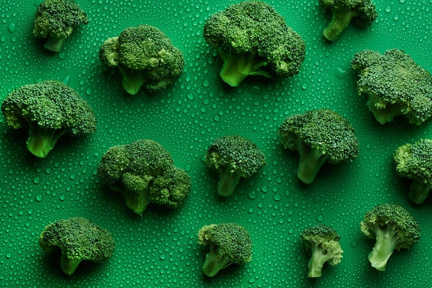 Modèle sans couture de brocoli cru frais sur fond vert, vue de dessus. Le concept d'aliments sains, de régime alimentaire, de sulforaphane, de légumes crucifères