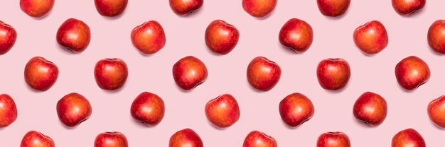 Modèle sans couture de pommes sur fond rose.