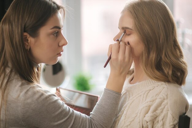 Le modèle se fait maquiller par une maquilleuse dans un salon de beauté