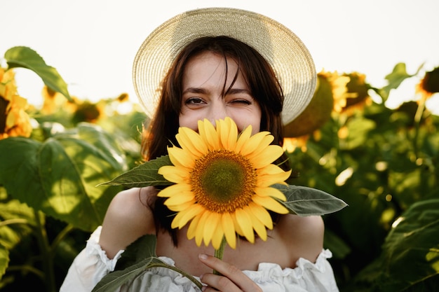 Modèle séduisant de jeune femme posant dans le champ de tournesols