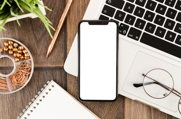 Photo modèle de smartphone de la vue de dessus sur l'espace de travail