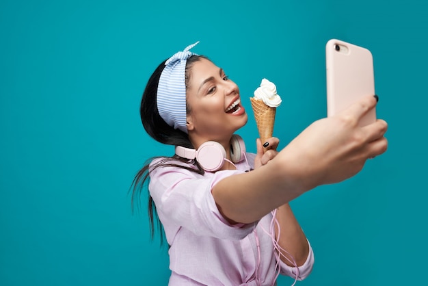 Modèle souriant prenant selfie, tenant des glaces.