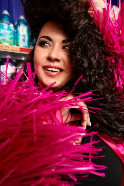 Photo modèle de taille plus féminine posant dans le studio portrait frontal en plumes de rose la femme est