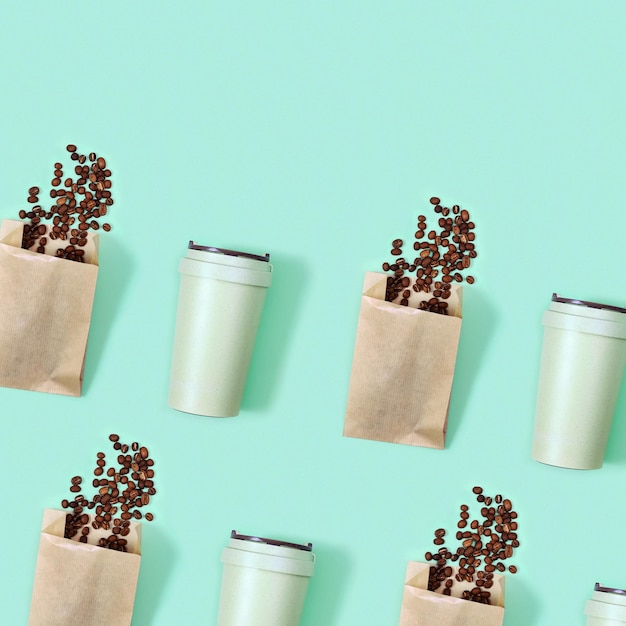 Modèle avec tasse à café écologique réutilisable en bambou et grains de café torréfiés dans un sac en papier