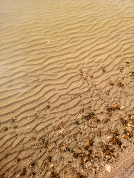 Modèle de vagues d'eau peu profonde de sable sur le sable sous l'eau