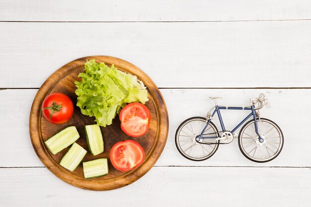 Modèle de vélo et légumes frais sur un bureau en bois blanc