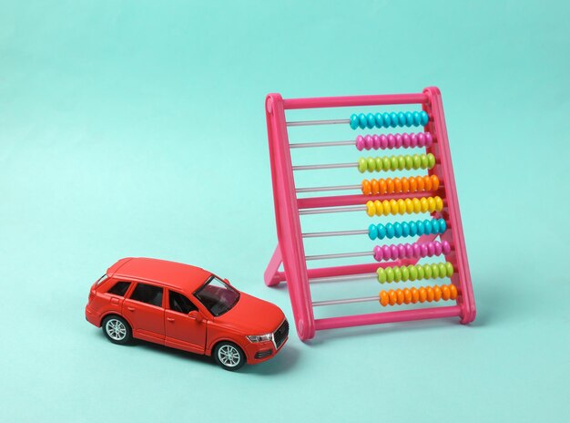 Photo modèle de voiture jouet avec abacus sur fond bleu calcul du coût achat de voiture consommation de carburant coûts de service de voiture