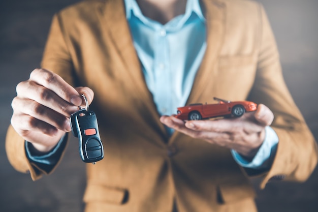 Modèle de voiture main homme avec clé sur fond sombre