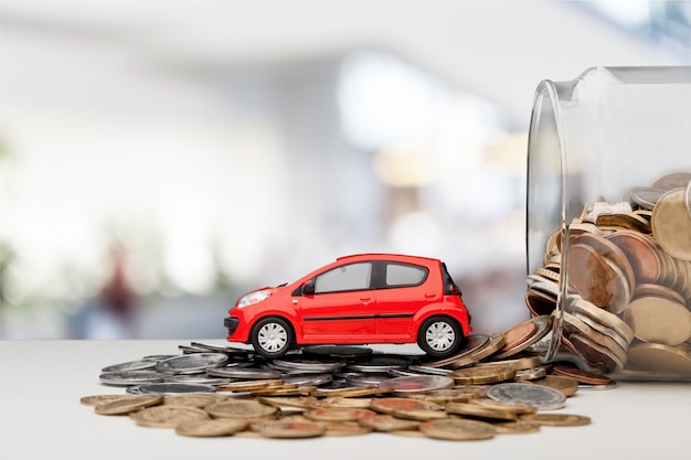 Modèle de voiture miniature et état financier avec pièces de monnaie. Financement et crédit auto,