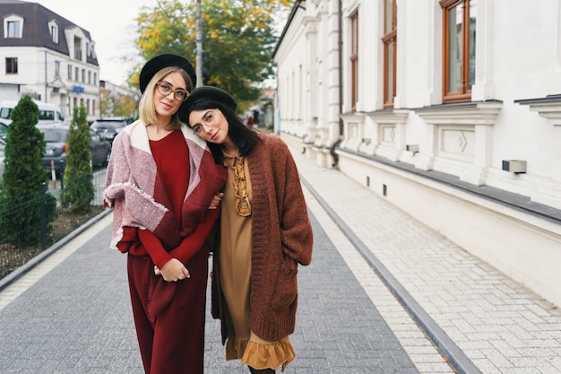 Modèles féminins en élégants vêtements et lunettes d'automne sur fond de ville urbaine