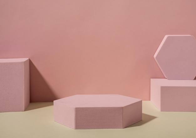 Modèles de formes géométriques roses, de carrés et d'hexagones, placés sur un sol sablonneux contre le mur avec des ombres. Copier le concept d'espace