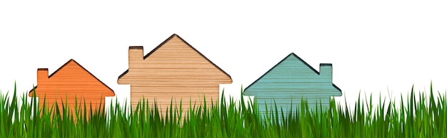 Modèles de maisons de différentes couleurs sur fond d'herbe verte. Fond isolé. Concept pour la publicité immobilière. Acheter, vendre, louer une maison. Hypothèque. Espace de copie. Format bannière.