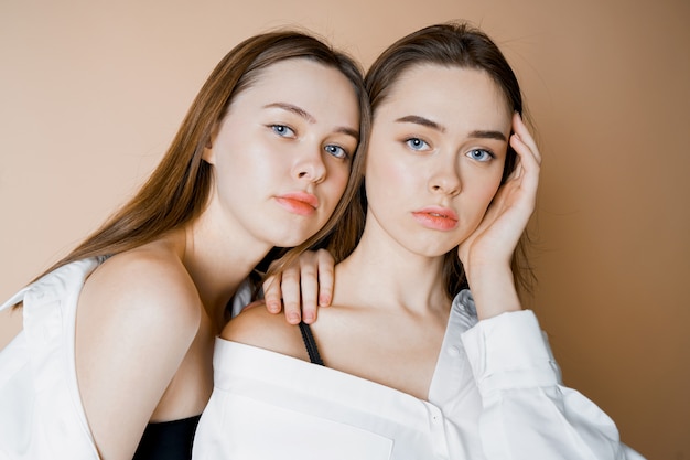 Modèles de mode deux soeurs jumelles belles filles nues regardant la caméra