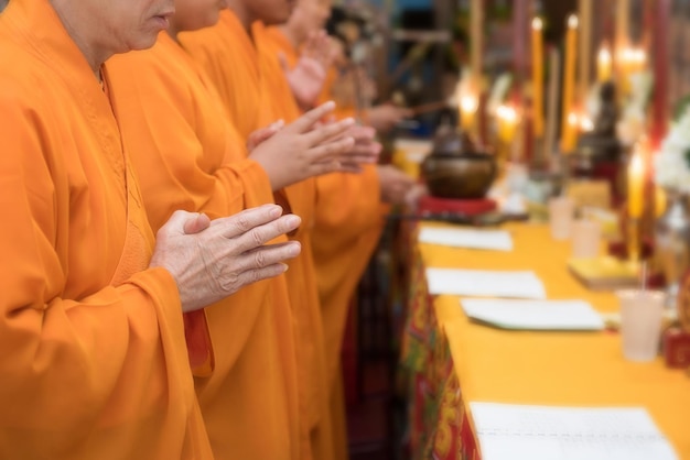 Moines bouddhistes priant les mains dans la prière rituelle