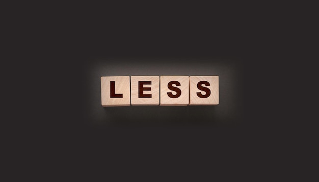 Photo moins de mots sur des blocs cubiques en bois dépenser moins ou réduire les coûts concept d'entreprise