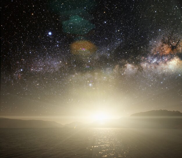 Mois sur un fond de ciel étoilé reflété dans la mer. Éléments de cette image fournis par la NASA