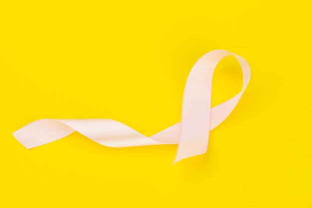 Mois de sensibilisation au cancer du sein d'octobre, ruban rose sur jaune