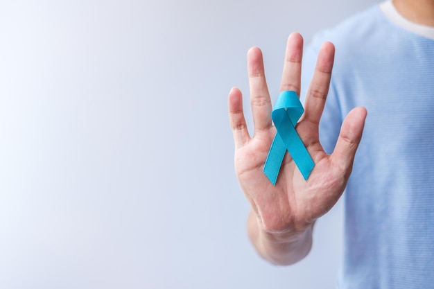 Mois de la sensibilisation au cancer de la prostate de novembre bleu Homme en chemise bleue avec la main tenant le ruban bleu pour soutenir la vie et la maladie des personnes Soins de santé Hommes internationaux Père Diabète et Journée mondiale du cancer