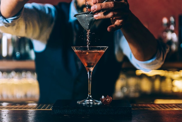 La moitié d'un barman préparant un cocktail dans un bar