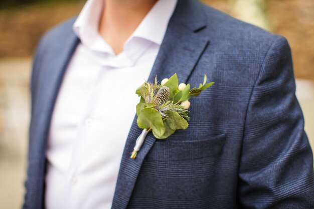 Photo la moitié du marié avec des fleurs sur le costume