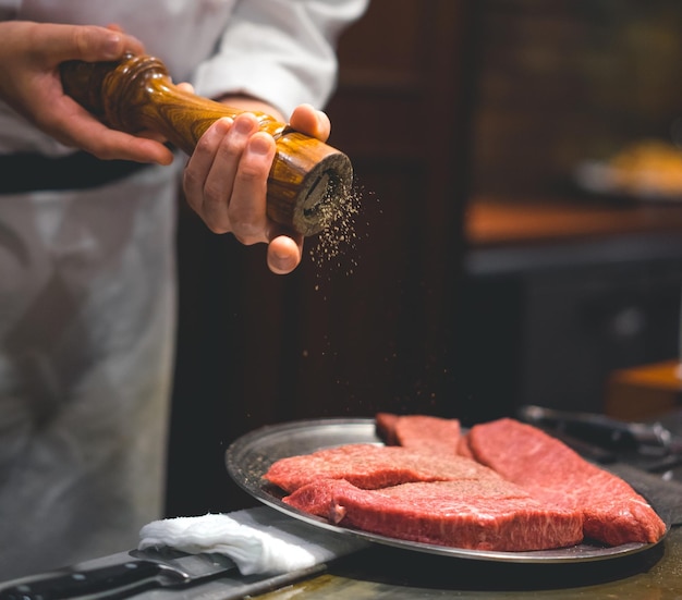 La moitié du sel d'assaisonnement du chef sur la viande