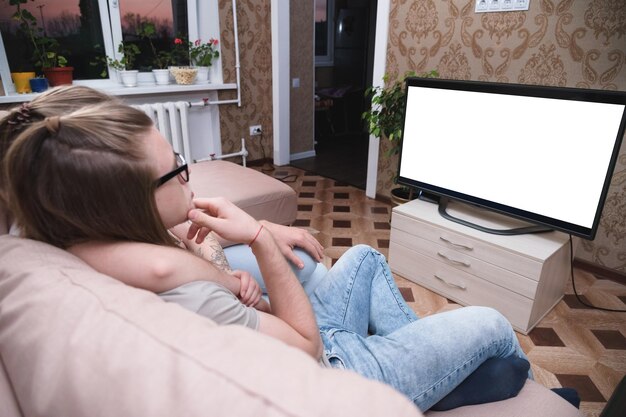 La moitié d'une femme assise sur le canapé à la maison