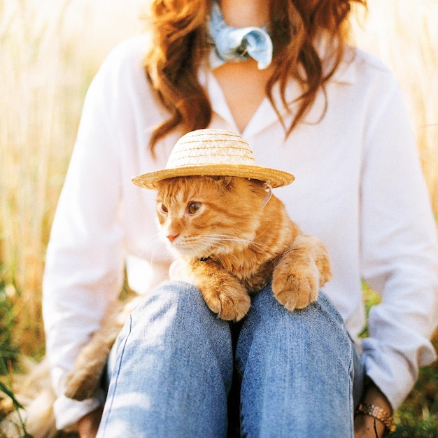 Photo la moitié d'une femme avec un chat assise à l'extérieur