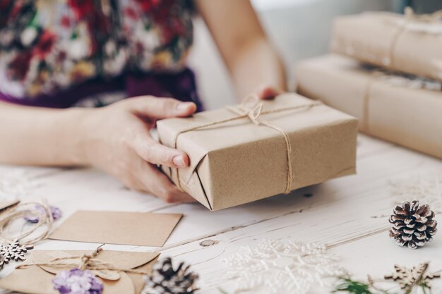 Photo la moitié d'une femme emballant un cadeau sur la table