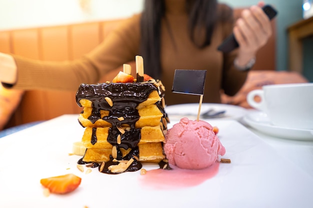 Photo la moitié d'une femme avec un gâteau au chocolat sur la table