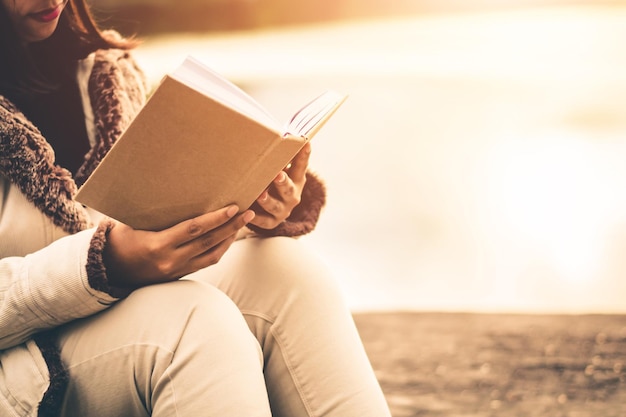 Photo la moitié d'une femme lisant un livre contre le lac