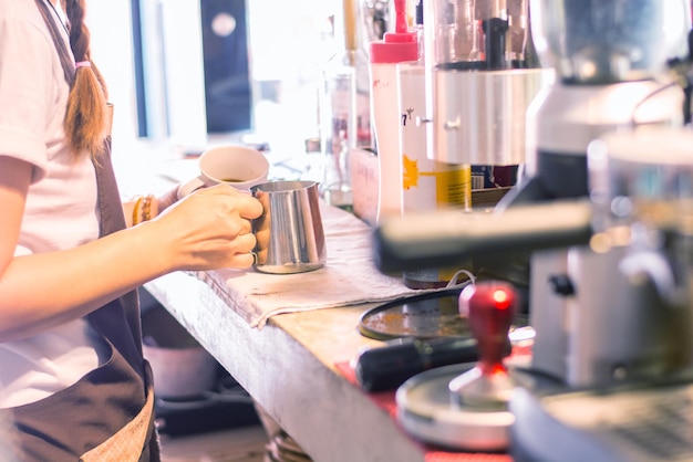 La moitié d'une femme préparant du café dans la cuisine