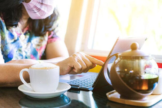 La moitié d'une femme avec une tasse de café sur la table