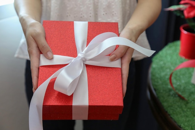 La moitié d'une femme tenant une boîte à cadeaux à Noël