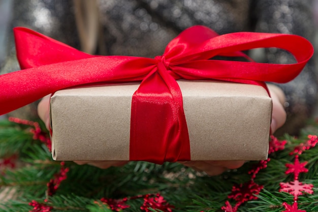 La moitié d'une femme tenant un cadeau de Noël à table